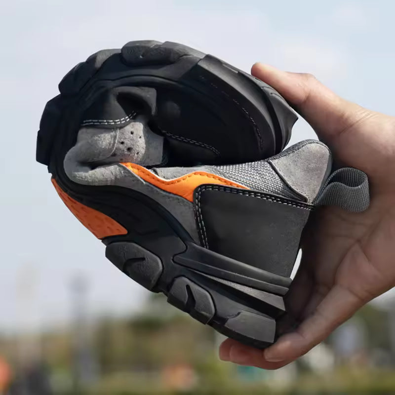 Person holding a gray and orange sandal with a blurred outdoor background