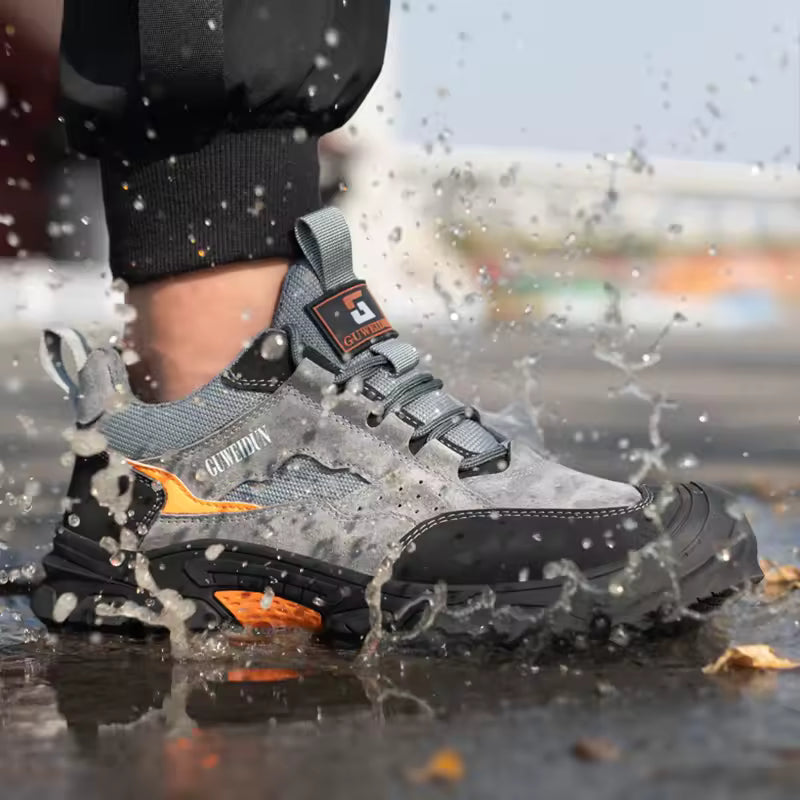 Person wearing gray and black shoes with orange accents walking through water.